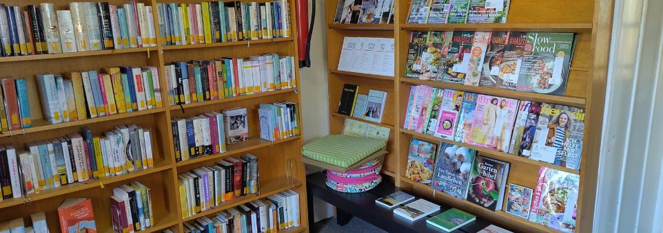 Bücherregal mit Romanen und Zeitungen