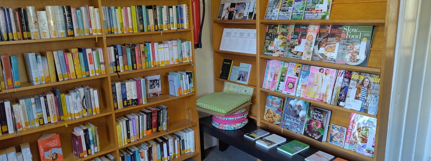 Bücherregal mit Romanen und Zeitungen